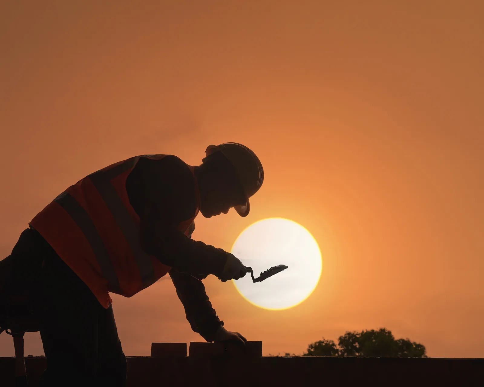 Silhouetted tradesperson against a low sun