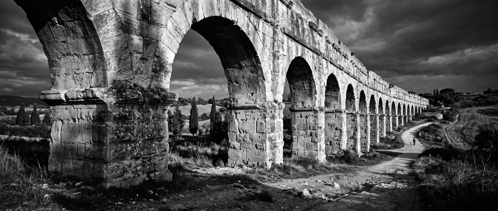 Ancient Roman aqueduct arches in dramatic black and white