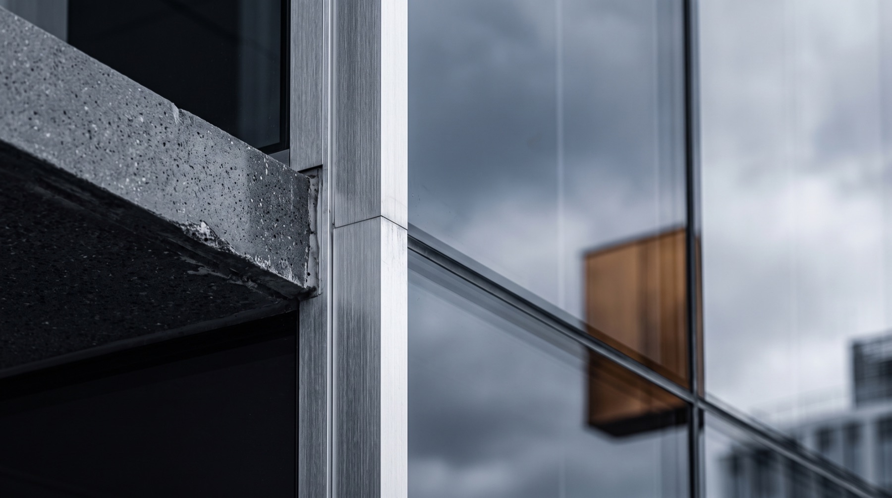 Polished concrete, aluminum mullion, and glass curtain wall meeting